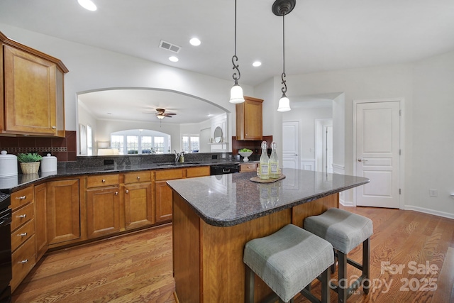 kitchen featuring sink, decorative light fixtures, a kitchen breakfast bar, kitchen peninsula, and dishwasher