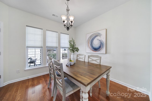 dining space featuring a notable chandelier and dark hardwood / wood-style flooring