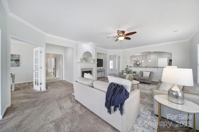 carpeted living room with crown molding and ceiling fan