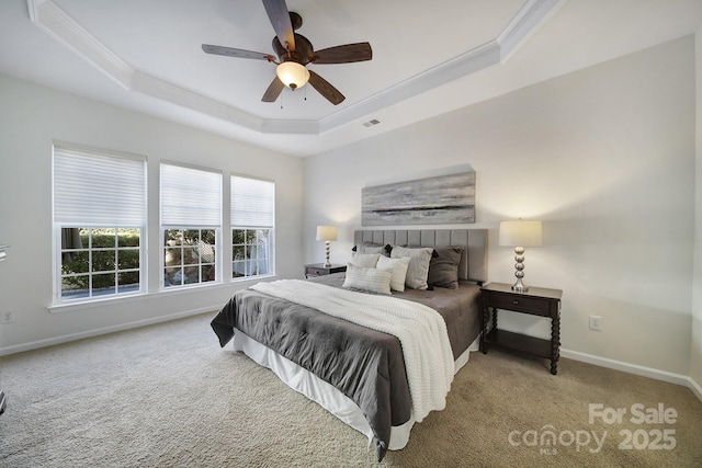 bedroom featuring ornamental molding, carpet floors, ceiling fan, and a tray ceiling