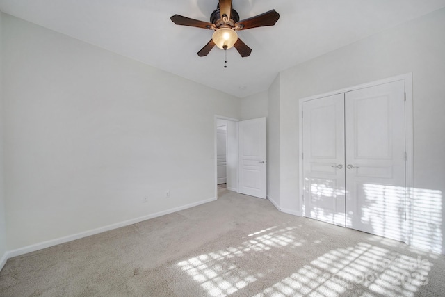 unfurnished bedroom featuring light carpet, ceiling fan, and a closet