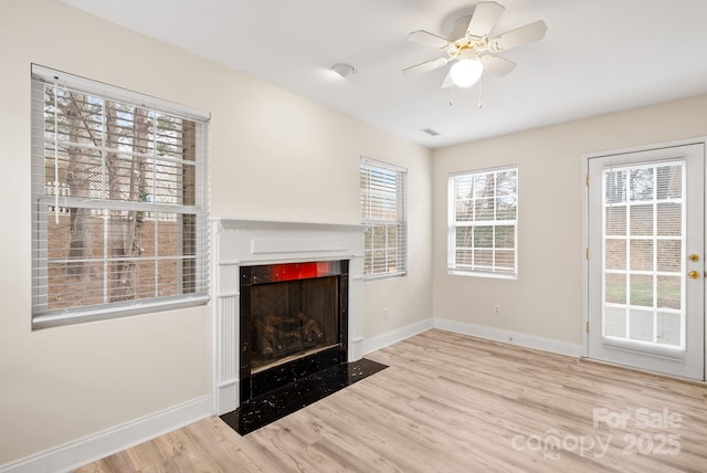 unfurnished living room featuring ceiling fan and light hardwood / wood-style floors