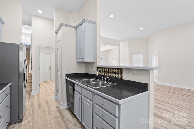 kitchen with stainless steel refrigerator with ice dispenser, sink, light wood-type flooring, gray cabinets, and dishwashing machine