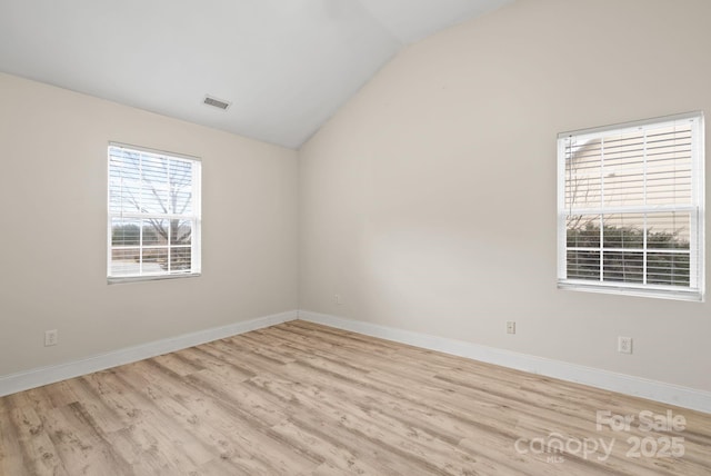 empty room featuring lofted ceiling and light wood-type flooring