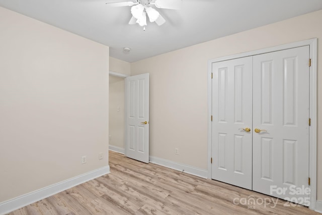 unfurnished bedroom featuring ceiling fan, a closet, and light wood-type flooring