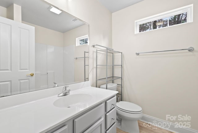 bathroom with vanity, hardwood / wood-style flooring, toilet, and walk in shower