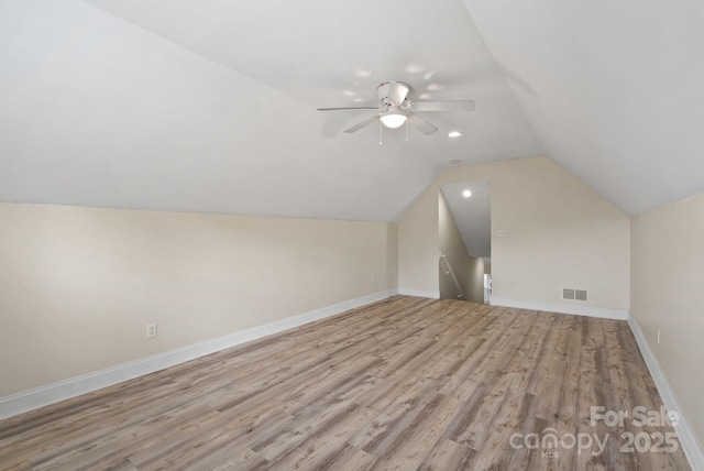 additional living space featuring lofted ceiling, light hardwood / wood-style flooring, and ceiling fan