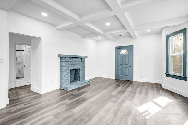 unfurnished living room featuring beam ceiling, a fireplace, baseboards, and wood finished floors