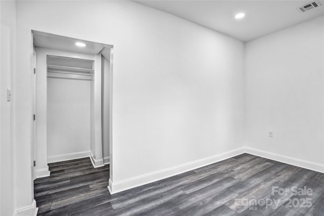 interior space featuring dark wood-style floors, baseboards, visible vents, and recessed lighting