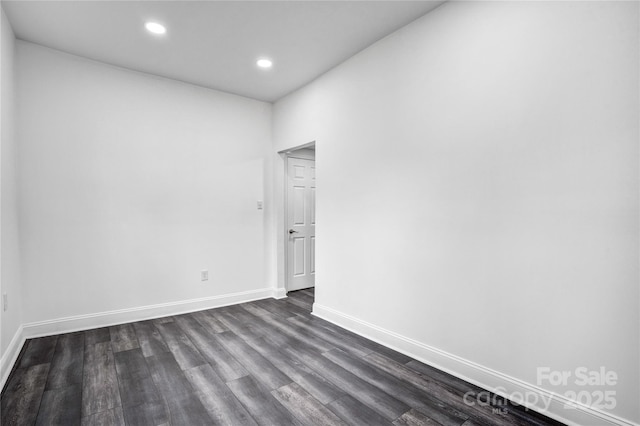 empty room featuring dark wood-style flooring, recessed lighting, and baseboards