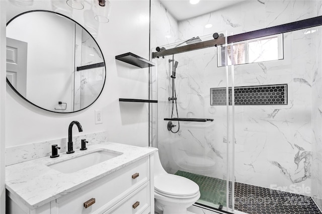 bathroom featuring a marble finish shower, vanity, and toilet