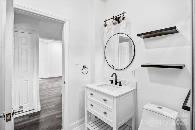 bathroom featuring toilet, wood finished floors, and vanity