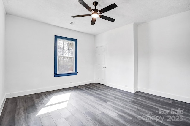 unfurnished room featuring dark wood-style floors, ceiling fan, a textured ceiling, and baseboards