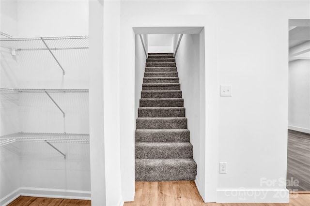 stairs with wood finished floors and baseboards