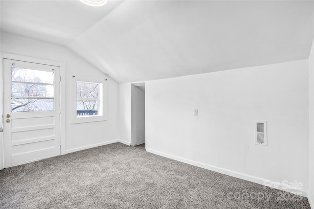 additional living space with lofted ceiling, baseboards, visible vents, and carpet flooring