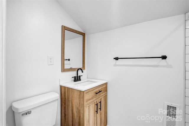 bathroom featuring visible vents, vaulted ceiling, vanity, and toilet