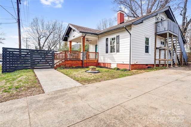 view of side of home featuring crawl space, stairs, a chimney, and roof with shingles