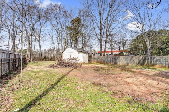 view of yard with fence private yard, a storage shed, and an outbuilding