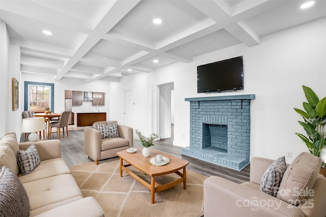 living room featuring a fireplace, recessed lighting, wood finished floors, coffered ceiling, and beamed ceiling