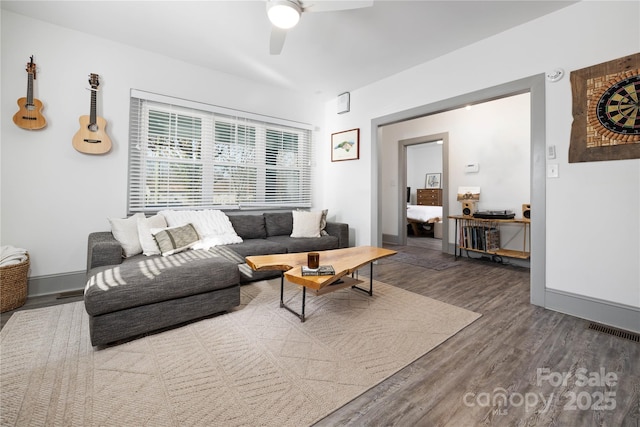 living room with dark wood-type flooring and ceiling fan