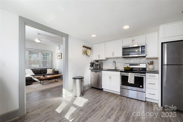 kitchen featuring white cabinetry, sink, backsplash, and appliances with stainless steel finishes