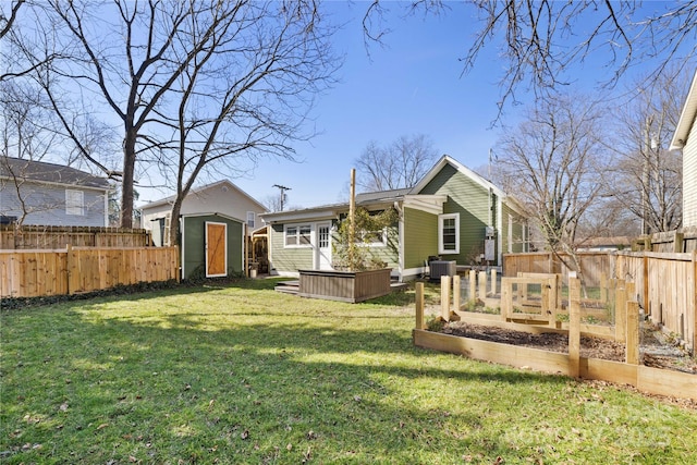 back of house featuring a yard, central AC, and a storage unit