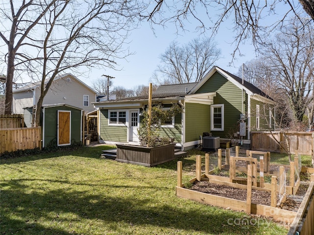 back of house featuring a storage shed, central AC unit, and a lawn