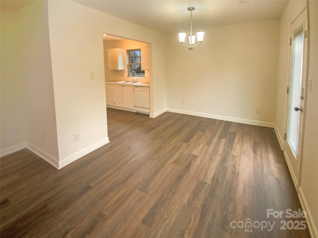 unfurnished dining area featuring dark wood-type flooring, sink, and a notable chandelier