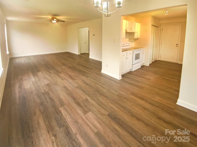 unfurnished living room featuring ceiling fan with notable chandelier and dark hardwood / wood-style floors