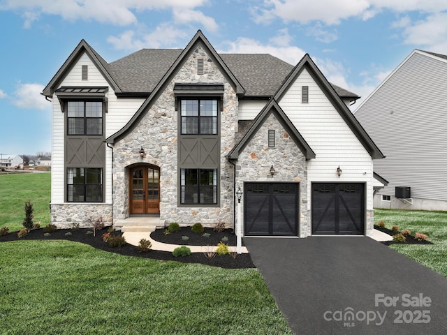 view of front of house featuring a garage, a front yard, and french doors