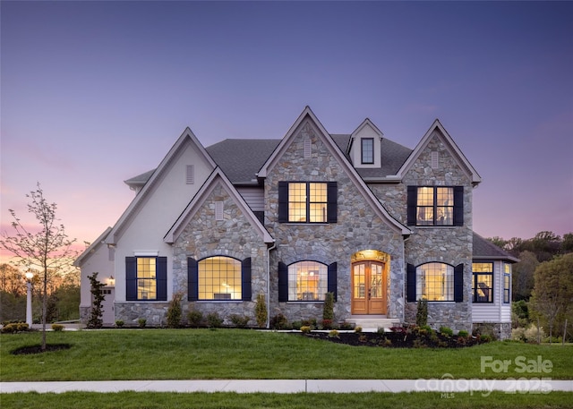 view of front of property with french doors and a lawn