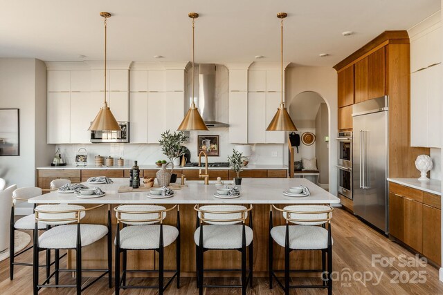 Lot11 Mayes Meadow Drive Devonshire, Cornelius, NC 28078 - kitchen featuring appliances with stainless steel finishes, wall chimney exhaust hood, modern cabinets, and a kitchen bar