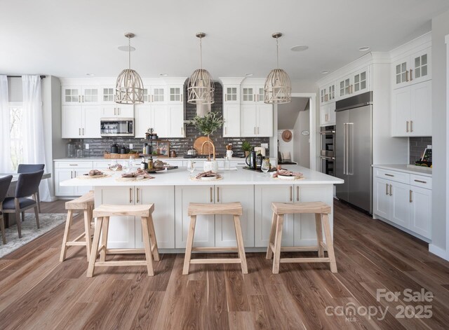Lot11 Mayes Meadow Drive Devonshire, Cornelius, NC 28078 - kitchen featuring appliances with stainless steel finishes, decorative backsplash, dark wood-style floors, and light countertops