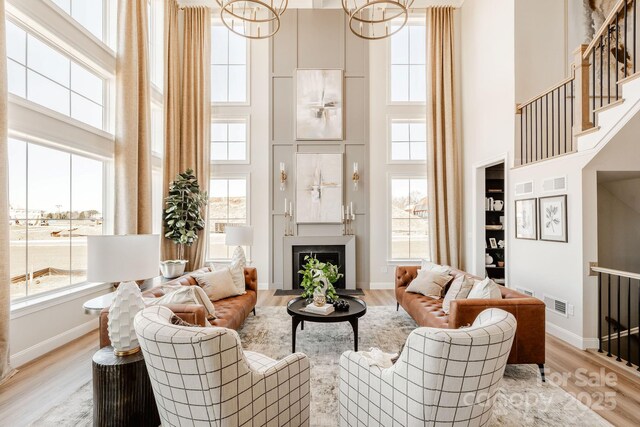 Lot11 Mayes Meadow Drive Devonshire, Cornelius, NC 28078 - living room with a high ceiling, a chandelier, healthy amount of natural light, light wood-style flooring, and a fireplace with flush hearth