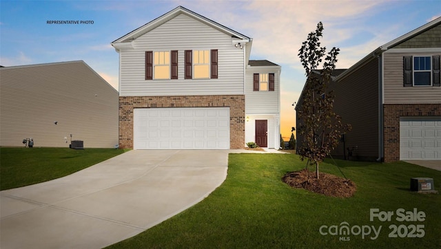 view of front of home featuring a garage, central AC, and a lawn