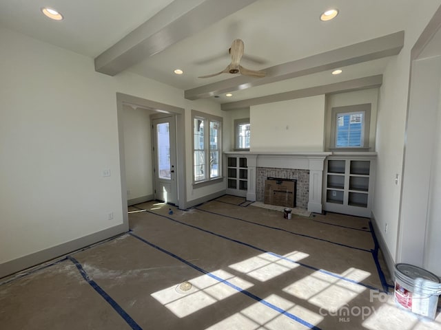 unfurnished living room with beamed ceiling and ceiling fan