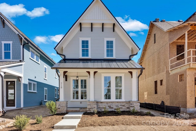 view of front facade featuring metal roof, a porch, and a standing seam roof