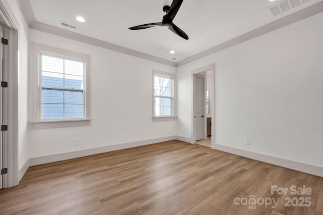 spare room featuring light wood-style floors, visible vents, and baseboards