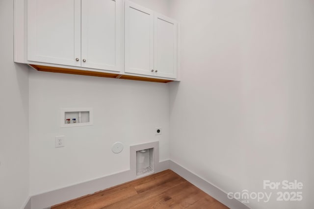 washroom with hookup for a washing machine, hookup for an electric dryer, baseboards, light wood-style floors, and cabinet space