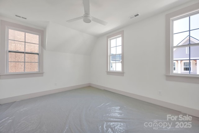 additional living space with baseboards, visible vents, vaulted ceiling, and a ceiling fan