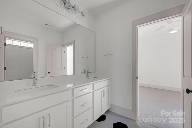 full bath with double vanity, a sink, visible vents, and baseboards