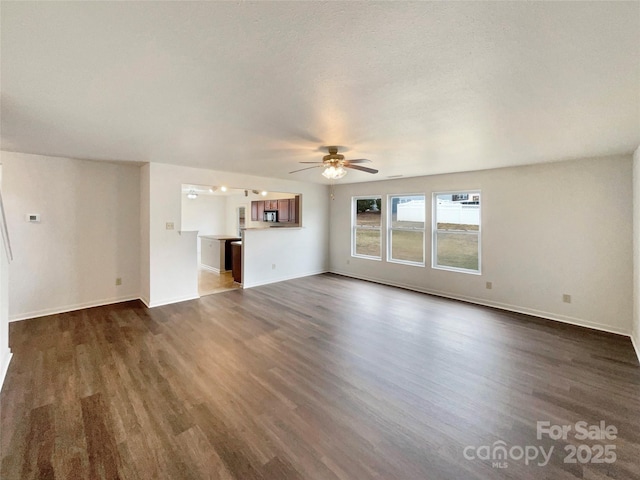 unfurnished living room with dark wood-type flooring and ceiling fan