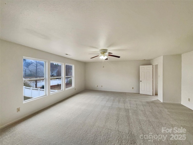 spare room featuring light carpet, a textured ceiling, and ceiling fan