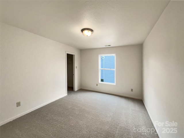 carpeted empty room featuring a textured ceiling