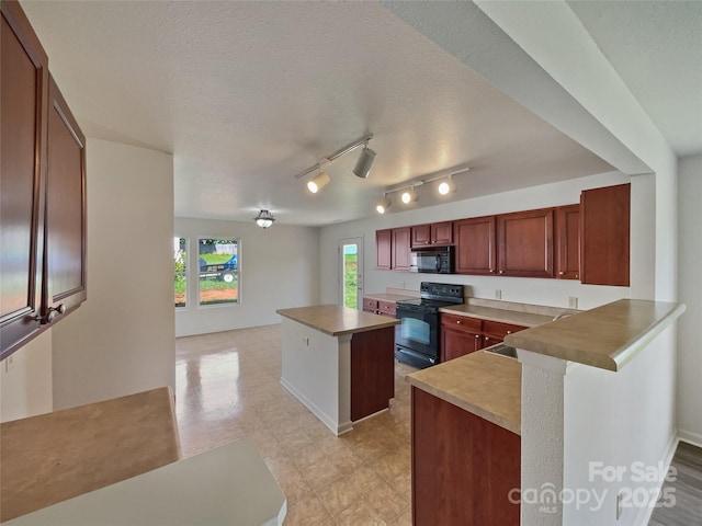 3418 Pikes Peak Dr, Gastonia, NC 28052 - kitchen featuring black appliances, a kitchen island, a peninsula, a sink, and a textured ceiling