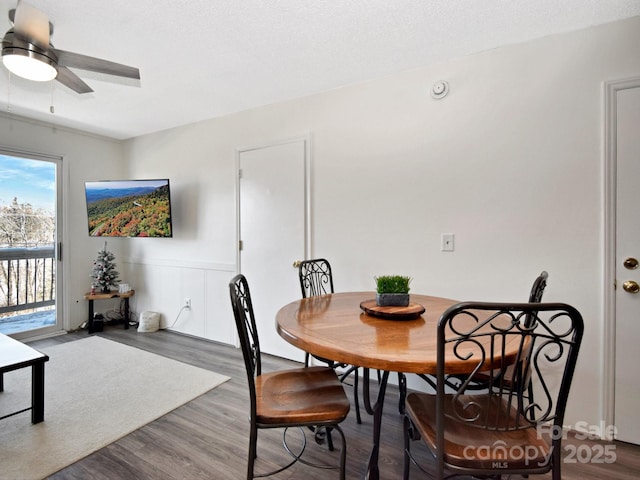 dining space featuring hardwood / wood-style flooring, ceiling fan, and a textured ceiling