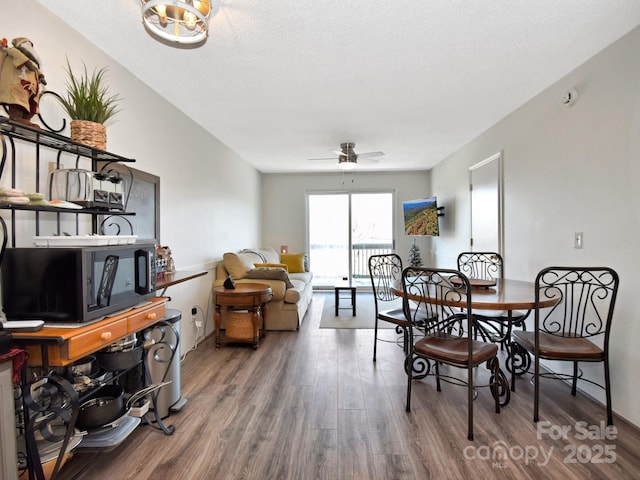 dining space featuring a textured ceiling, wood-type flooring, and ceiling fan