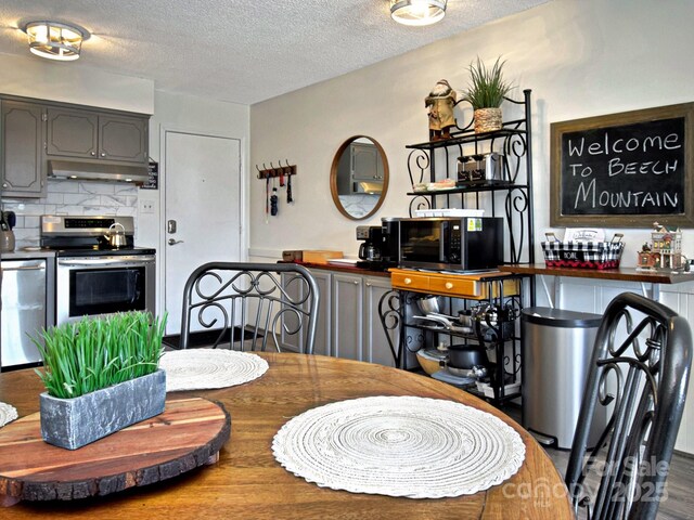 dining space with hardwood / wood-style flooring and a textured ceiling