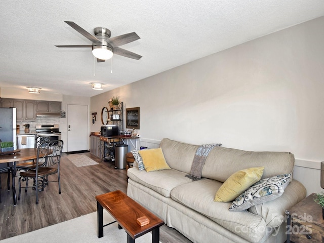 living room with ceiling fan, wood-type flooring, and a textured ceiling