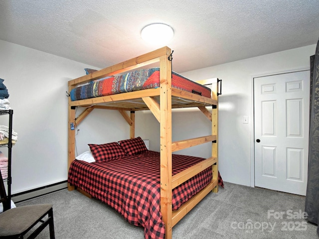 carpeted bedroom featuring a textured ceiling and a baseboard heating unit